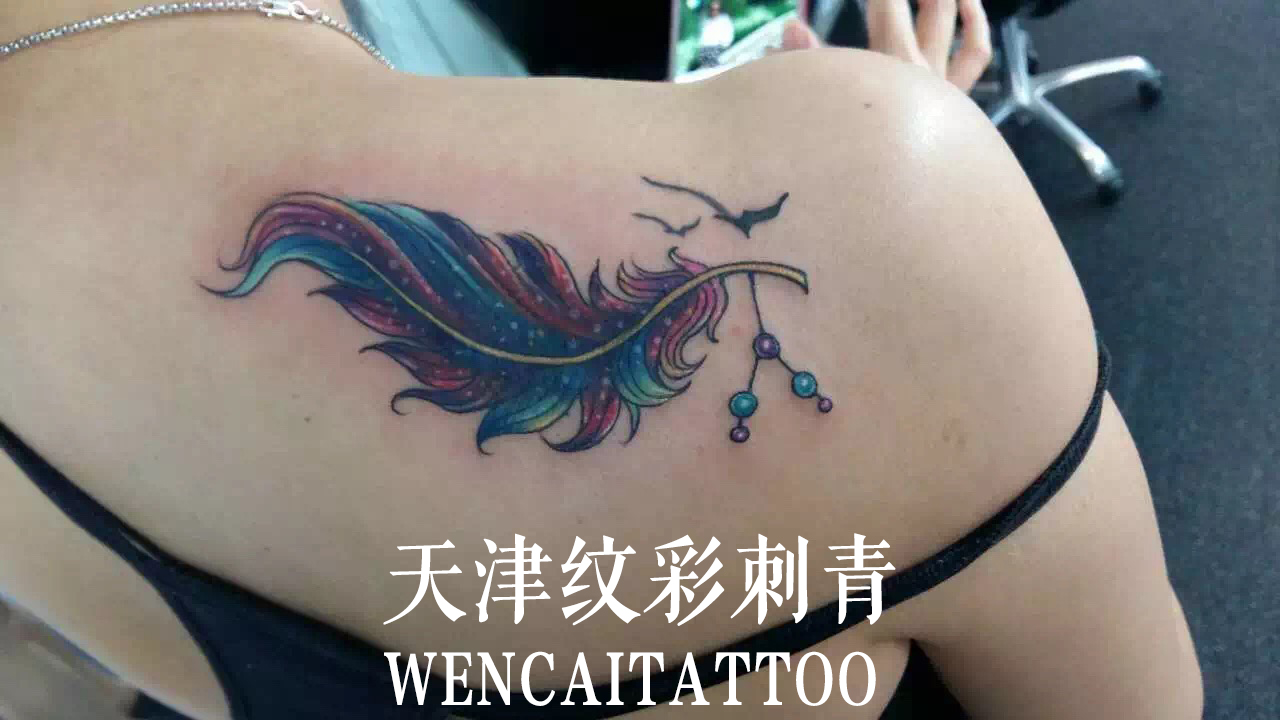 欧阳小姐的后背彩色羽毛纹身图案