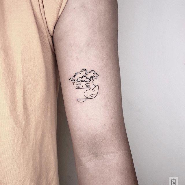 大臂上简约扭曲的人脸和乌云纹身图案